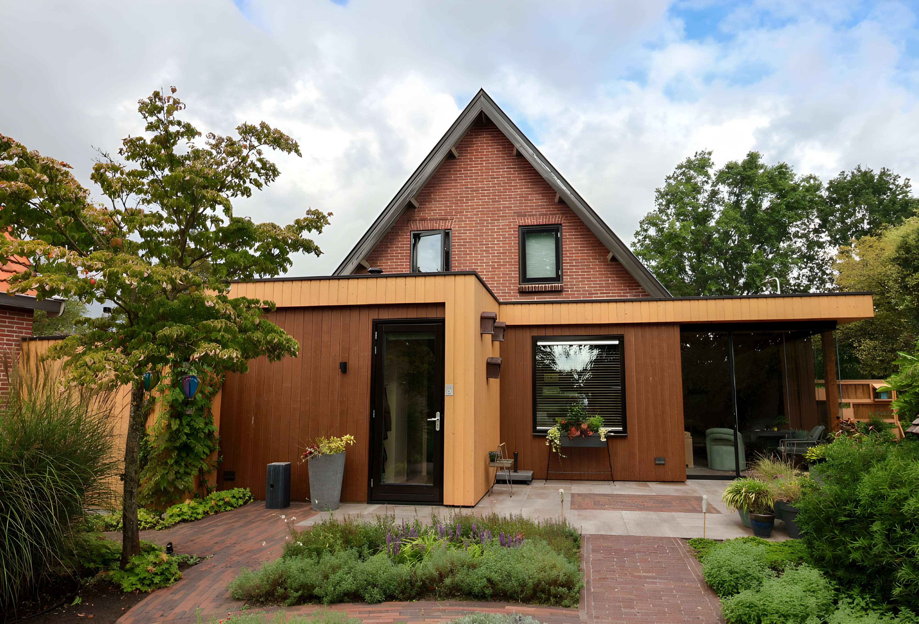 Houten uitbouw tegen een bakstenen woning